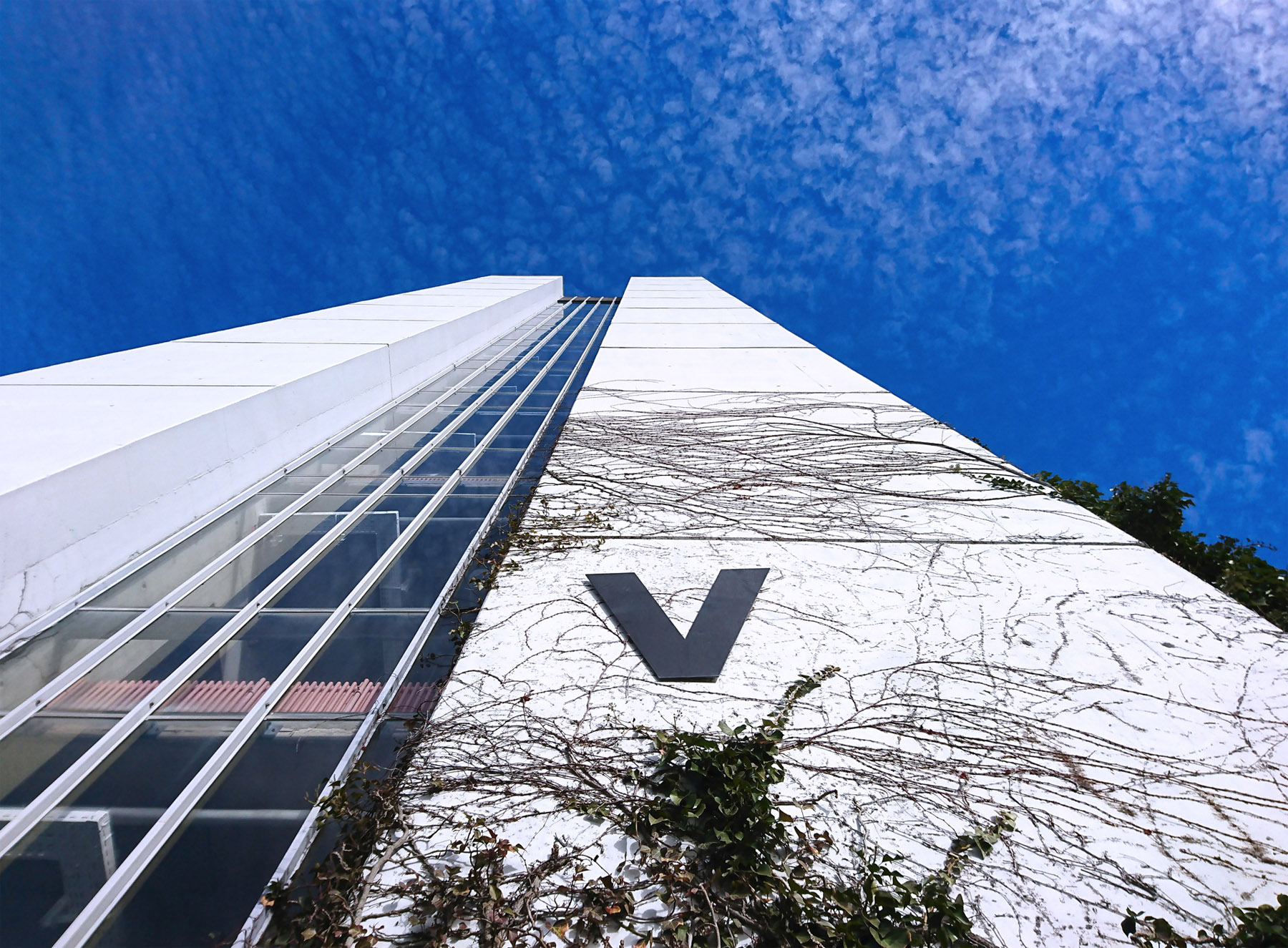 Außenansicht Gebäudeteil V vor blauem Himmel mit Wolken.