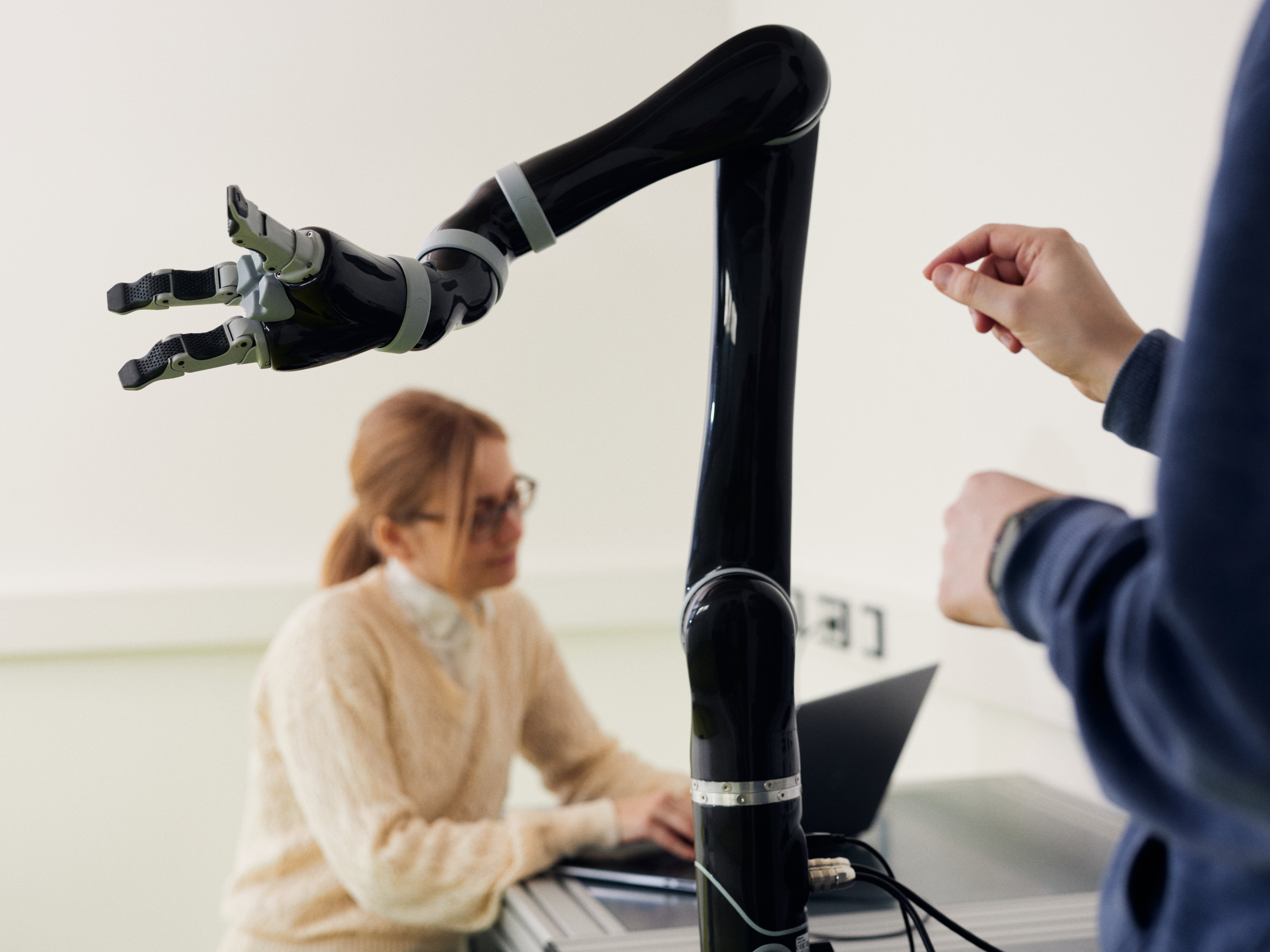 Two researchers work with a robot arm