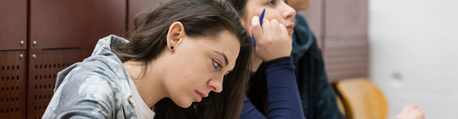 Zwei Studentinnen machen sich Notizen während einer Vorlesung