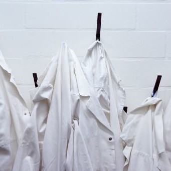 White lab coats on wall hooks