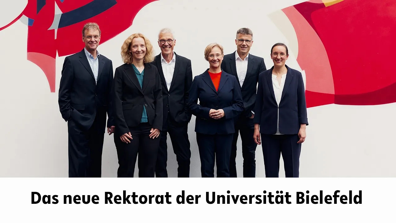 Die Rektoratsmitglieder stehen vor der Graffitiwand in der zentralen Uni-Halle. In der Bildunterschrift steht: Das neue Rektorat der Universität Bielefeld.