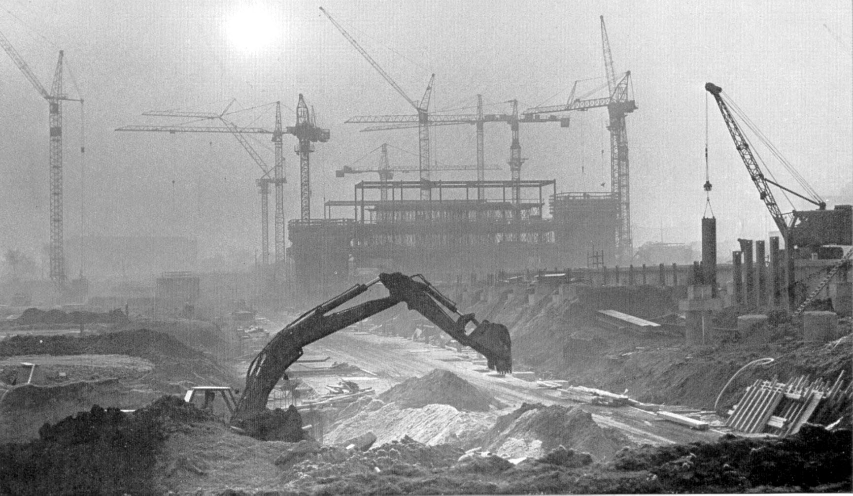 Photo: Excavator in front of university construction site with construction cranes, 1st half in 1970s